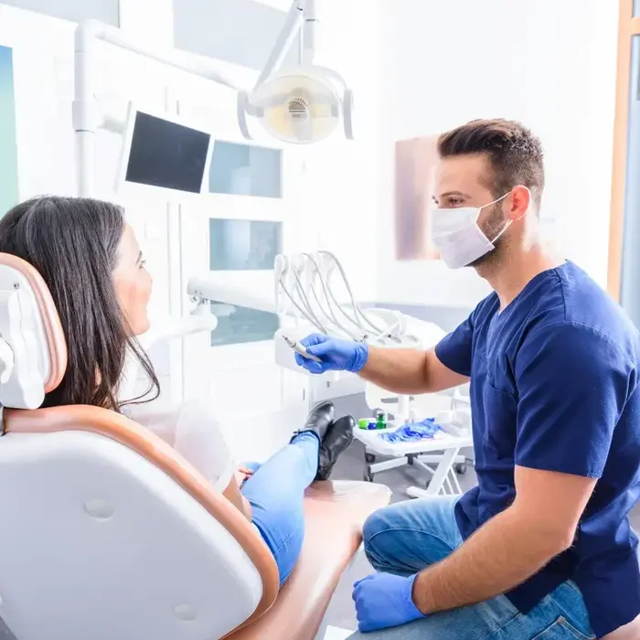 It is an image of dental clinic with a male dentist treating patient